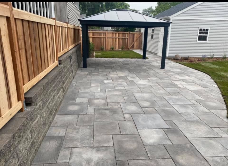 A patio with a gazebo in the backyard of a house.