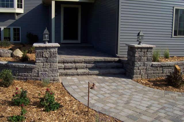 A brick walkway leading to the front door of a house.