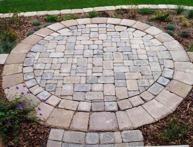 A circular walkway made of bricks in a garden.