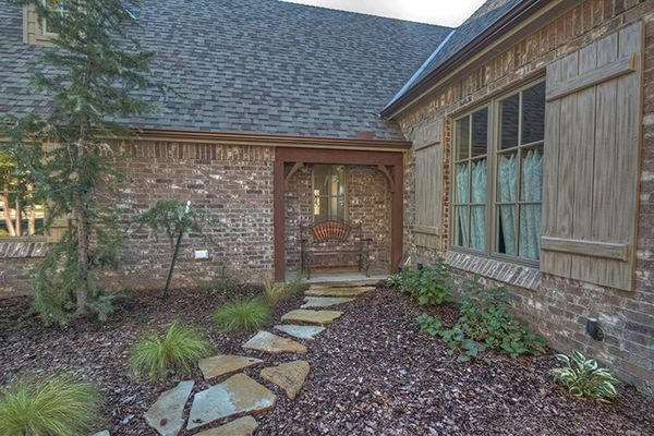 Exterior view of a brick house with a stone pathway leading to the front door.
