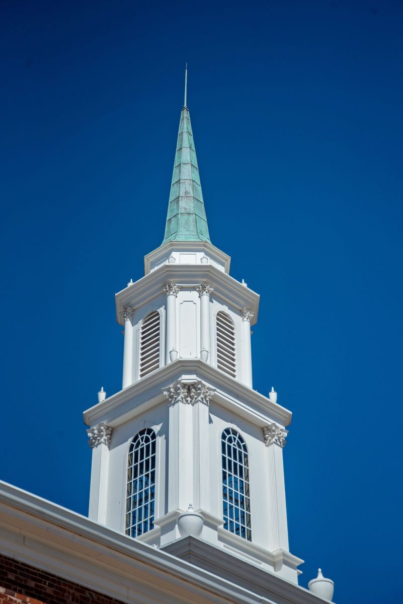 White church steeple with blue sky background.