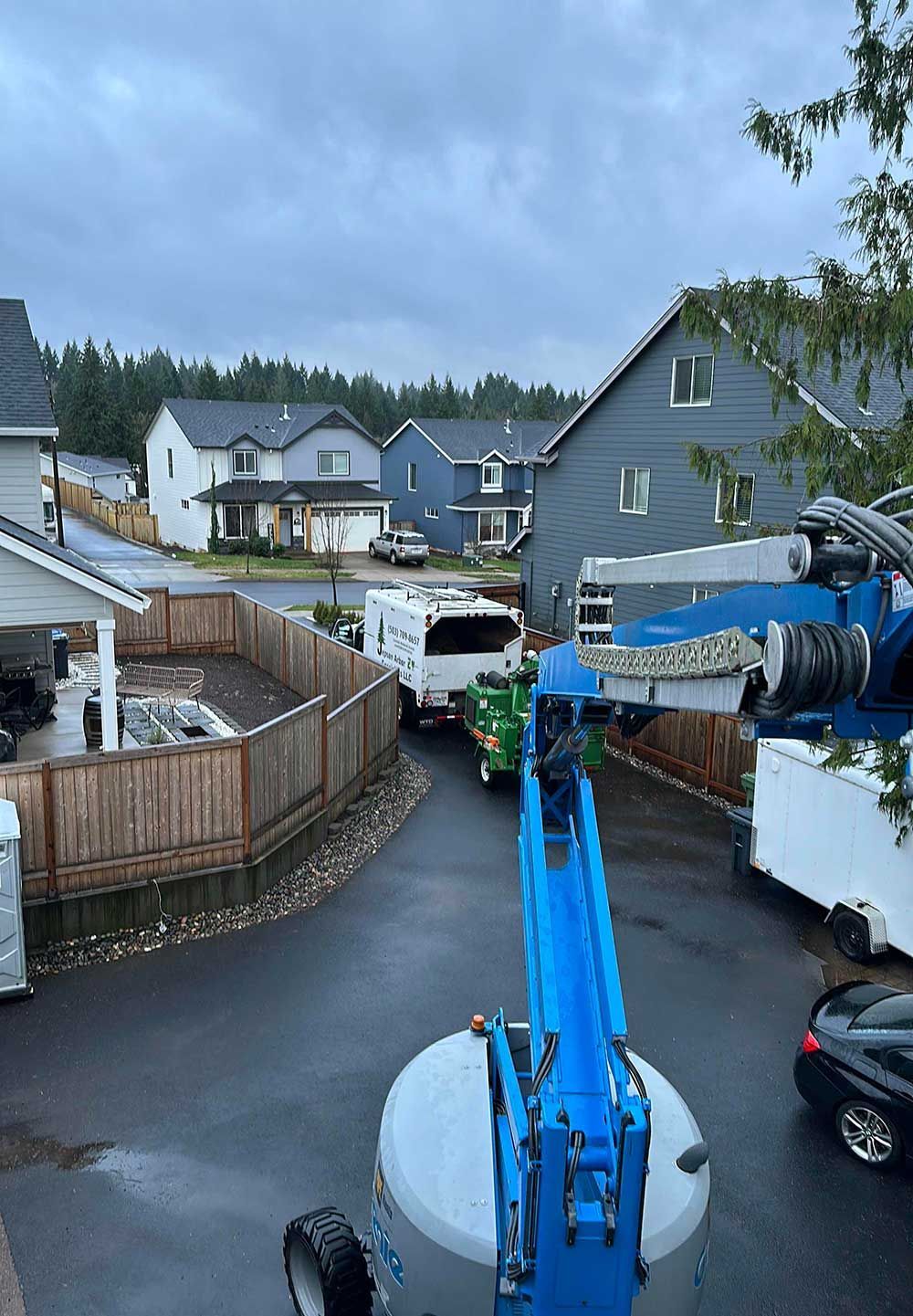 A group of trucks are parked in a driveway in a residential area.