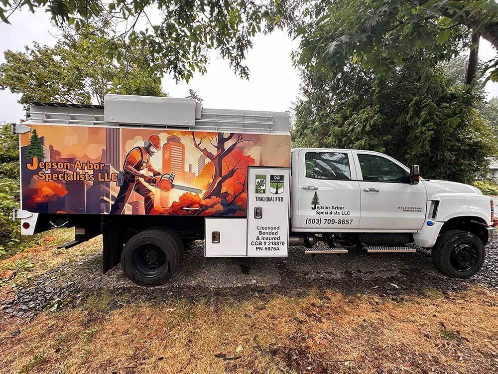 A white truck with a fireman on the side is parked in a field.