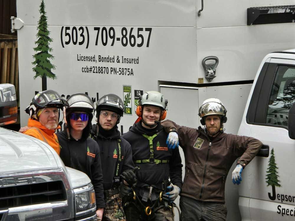 A group of men standing in front of a truck that says 503 709 8657