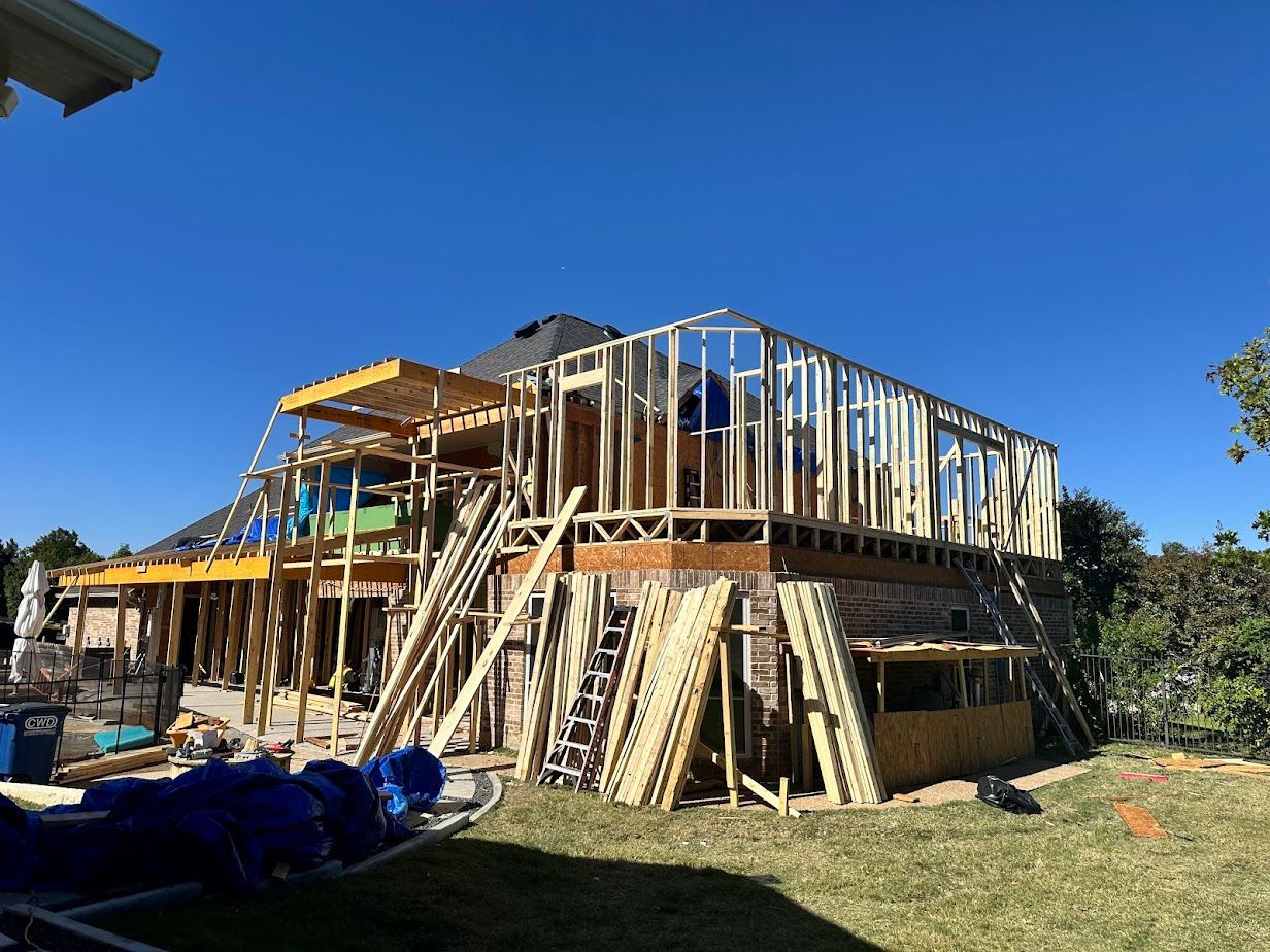Kitchen with black island, white cabinets, and wood subfloor, ready for flooring installation.
