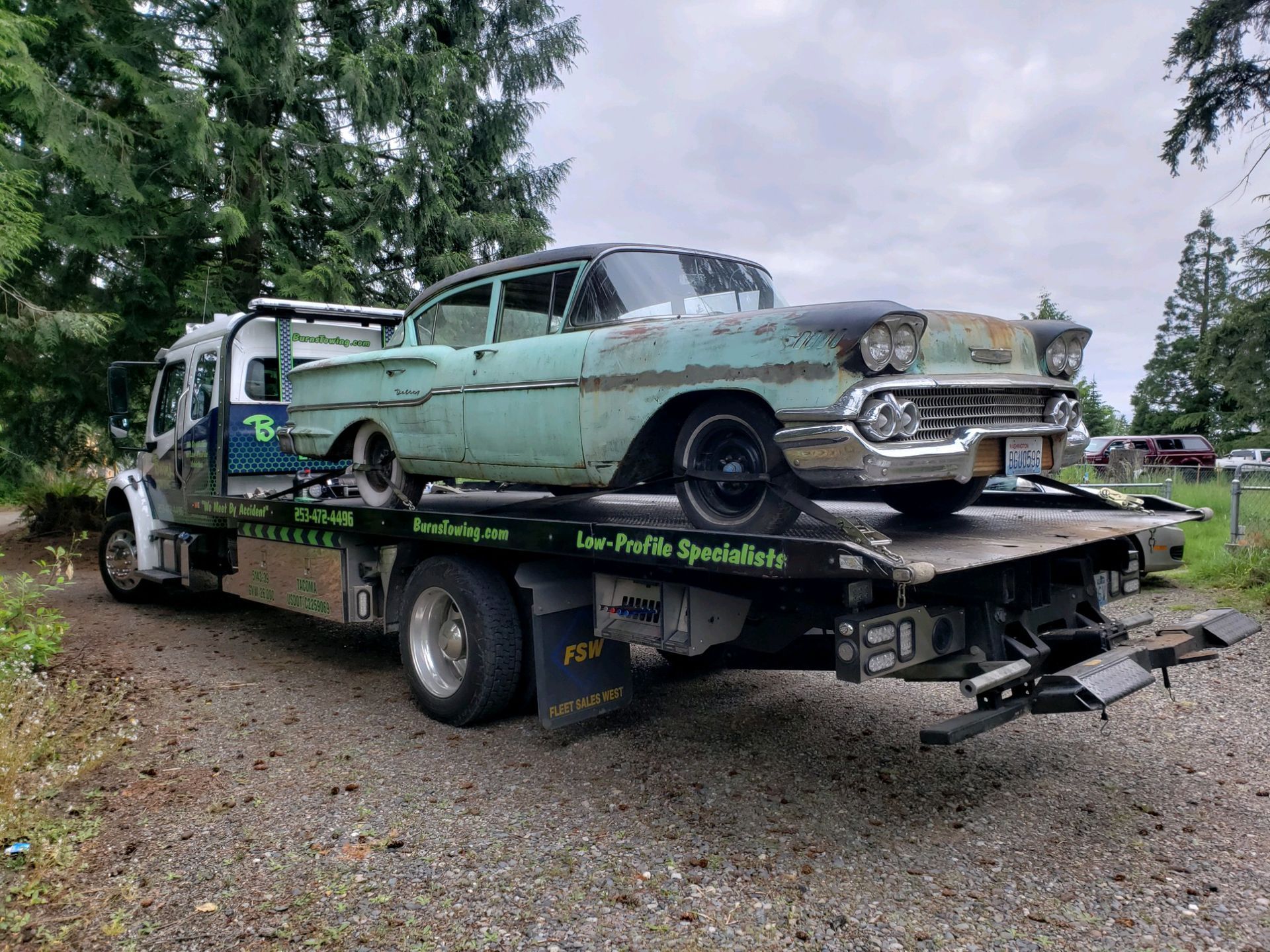 Old rusty car on a tow truck