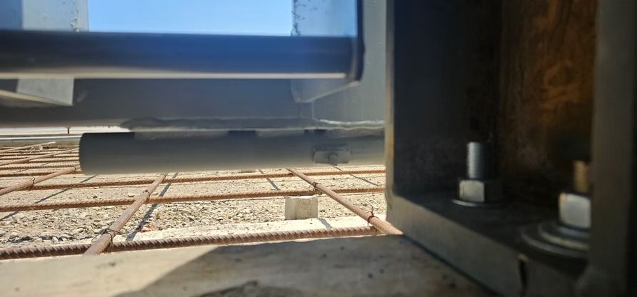 Close-up of a metal structure on rebar grid, possibly construction site.