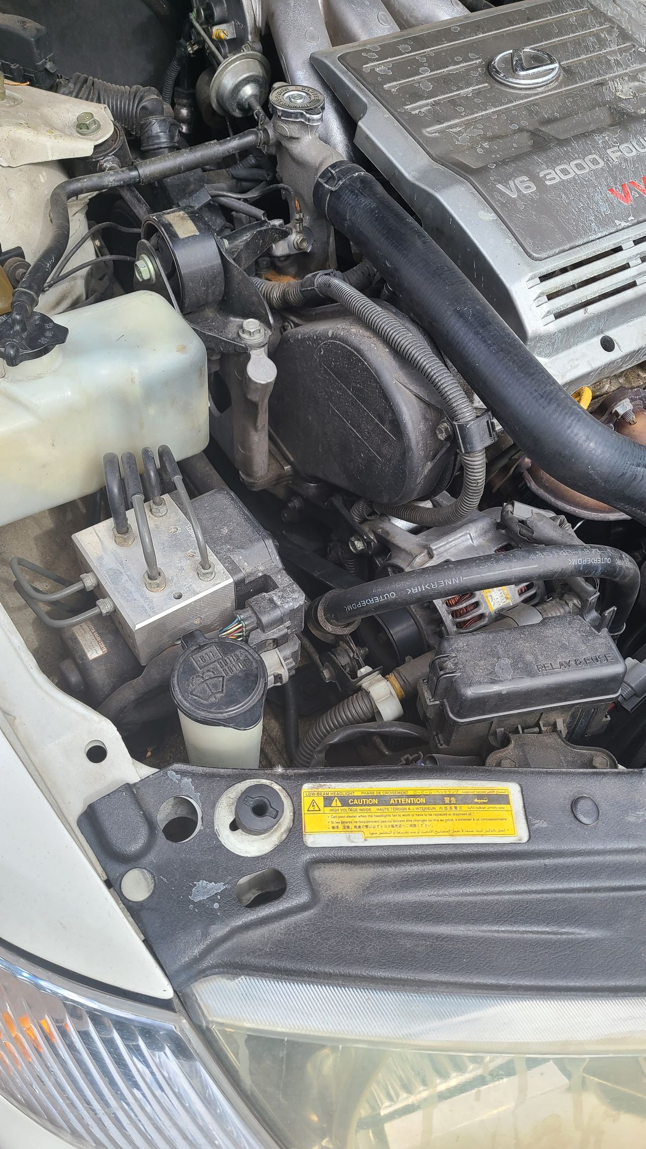 A close up of a car engine with the hood open.