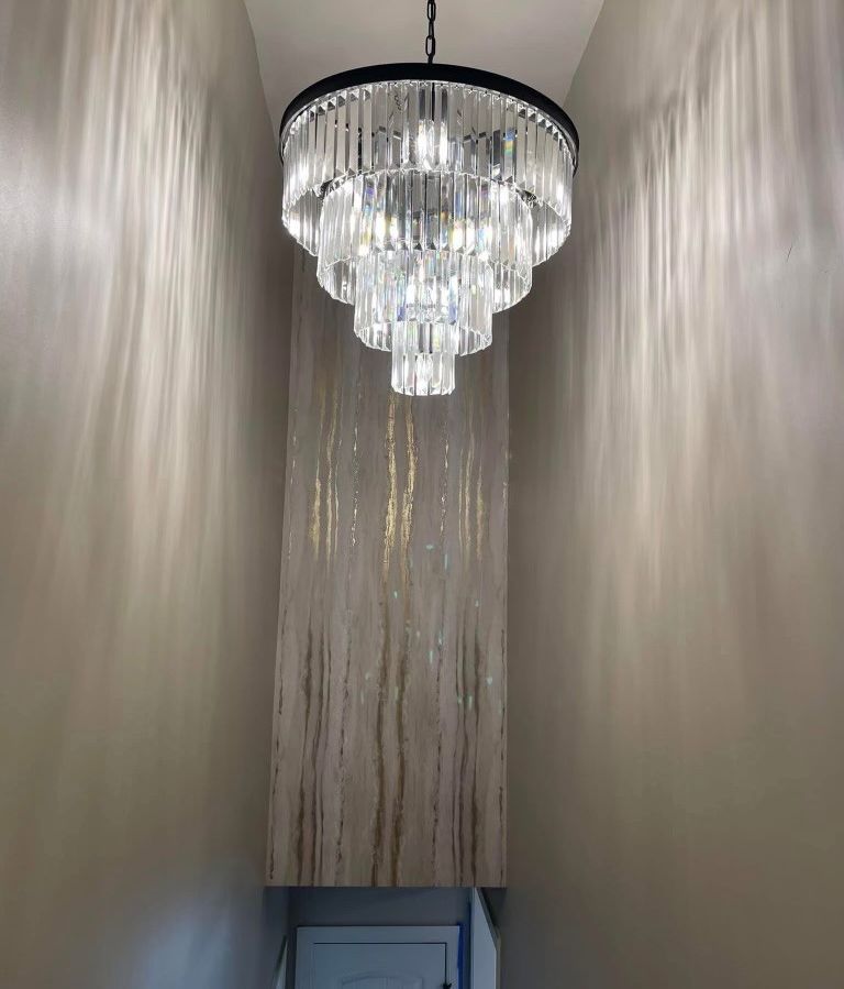 A chandelier is hanging from the ceiling in a hallway.