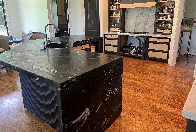 Large black countertop in the middle of the kitchen