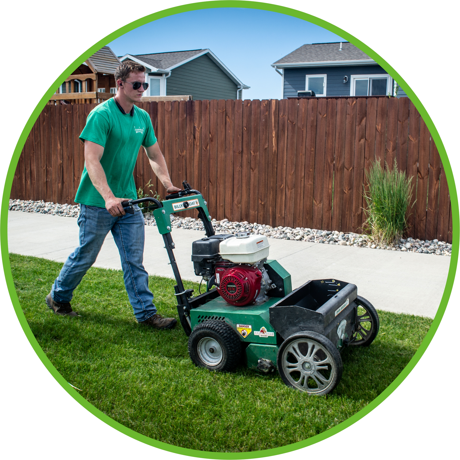 a man is pushing a lawn mower down a sidewalk
