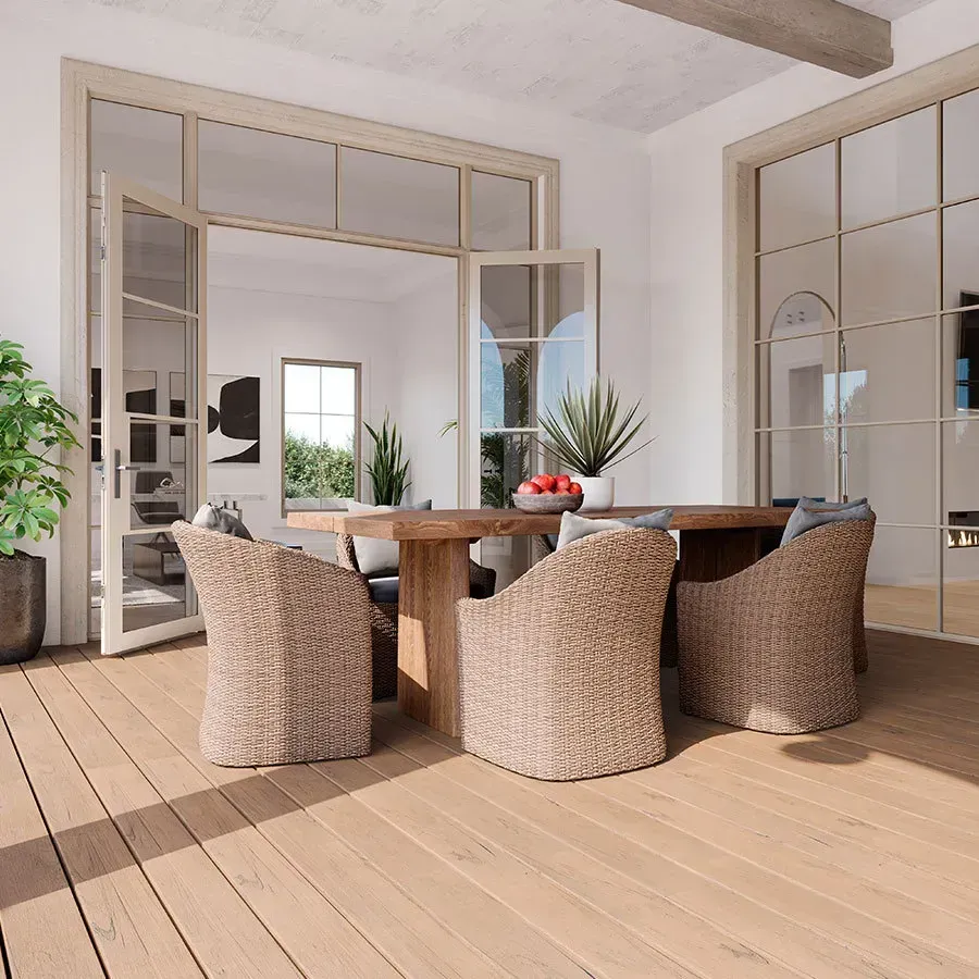 Outdoor dining area with wooden table, wicker chairs, and open glass doors.