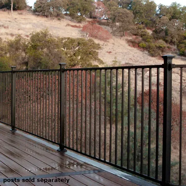 Black metal railing on a wooden deck overlooking a hillside with trees.