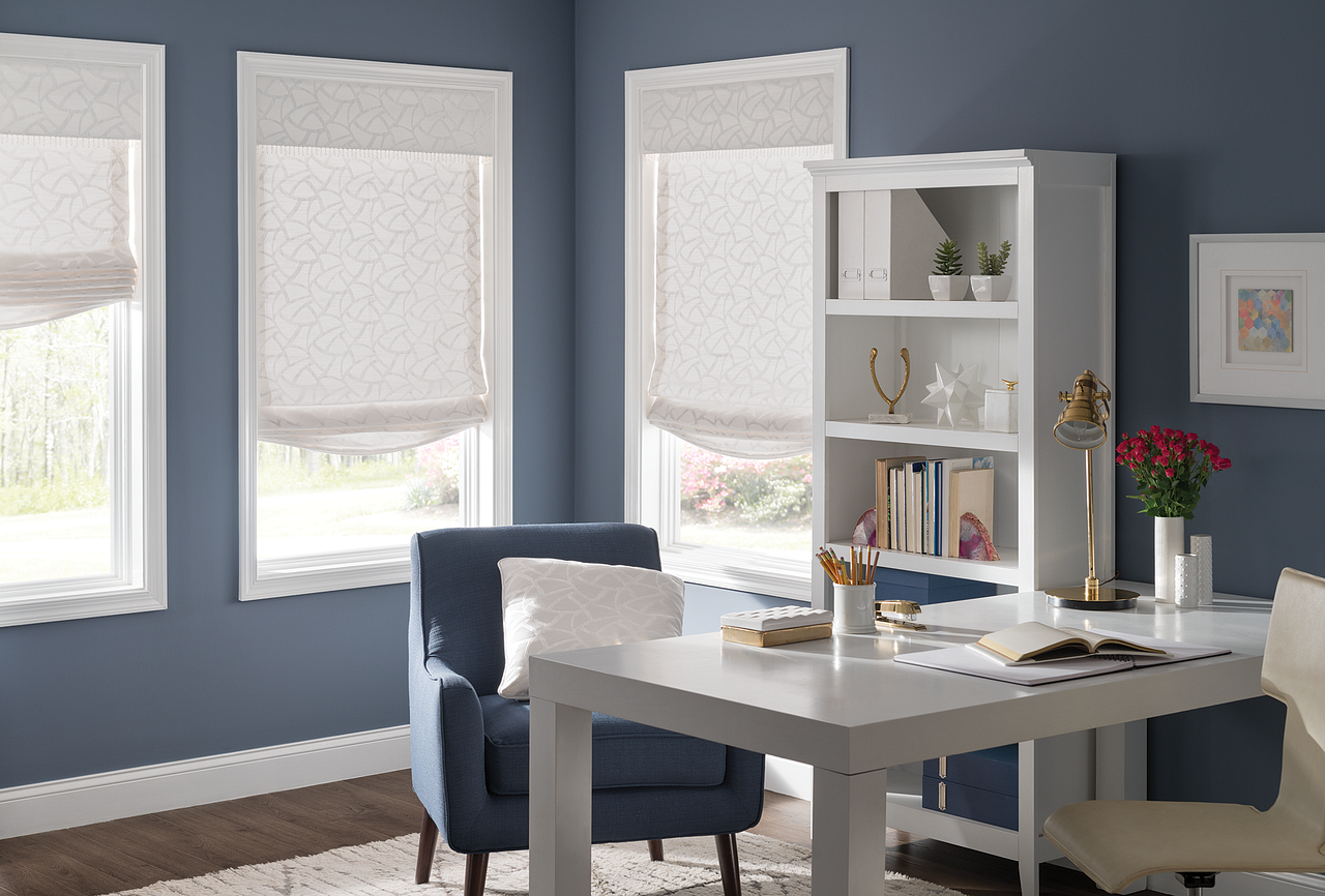 Bright home office with blue walls, white desk and shelves, blue chairs, and flowers by the window
