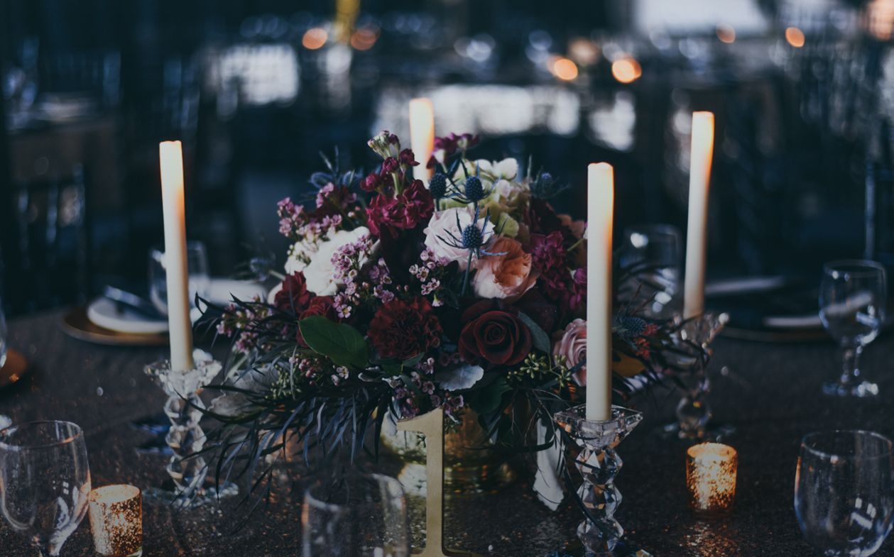 Floral centerpiece with candles on a table, creating a romantic setting.