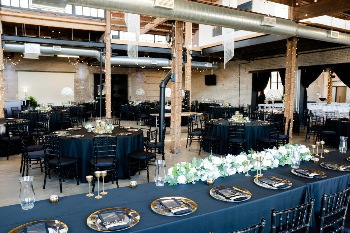 Event space with round tables, black linens, and floral centerpieces.