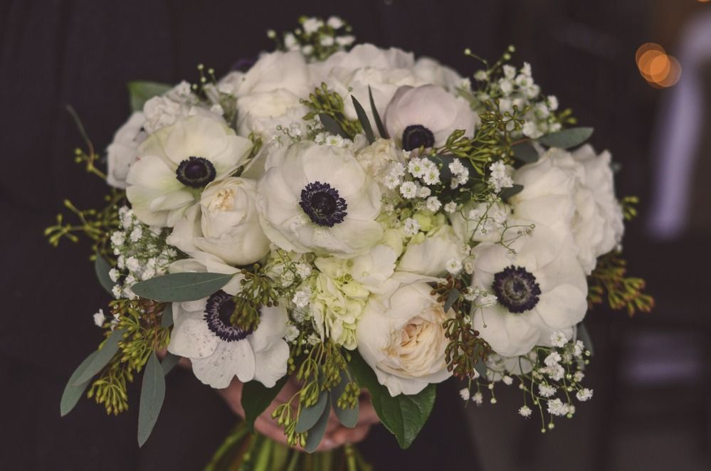 Close-up of a white floral bouquet with anemones and greenery.