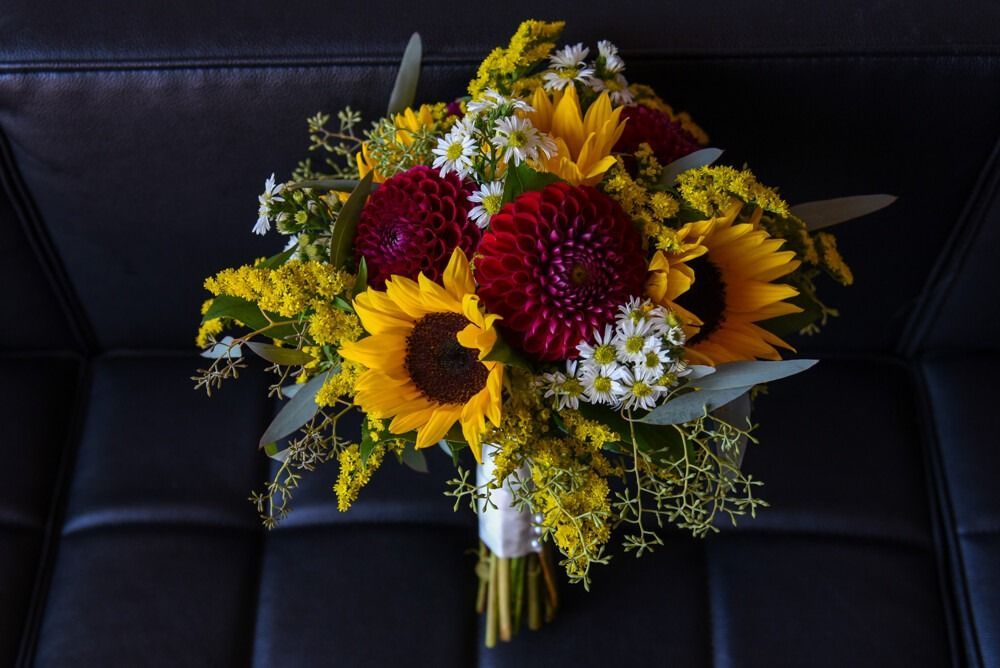 Sunflower and dahlia bouquet on black leather.