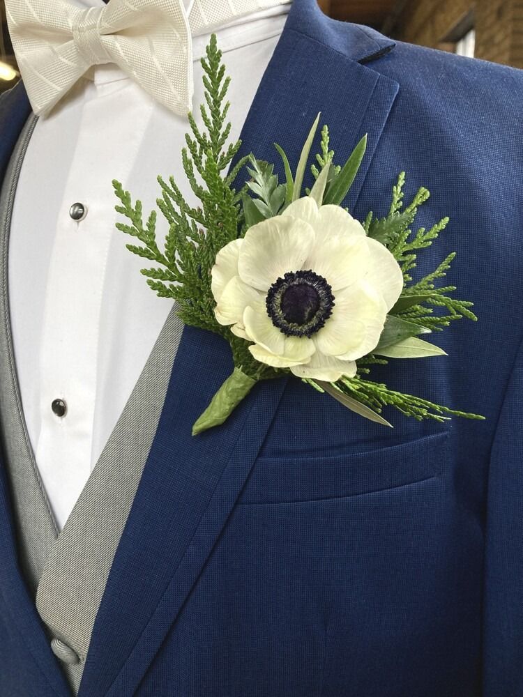 Blue suit with boutonniere: white anemone with green foliage.