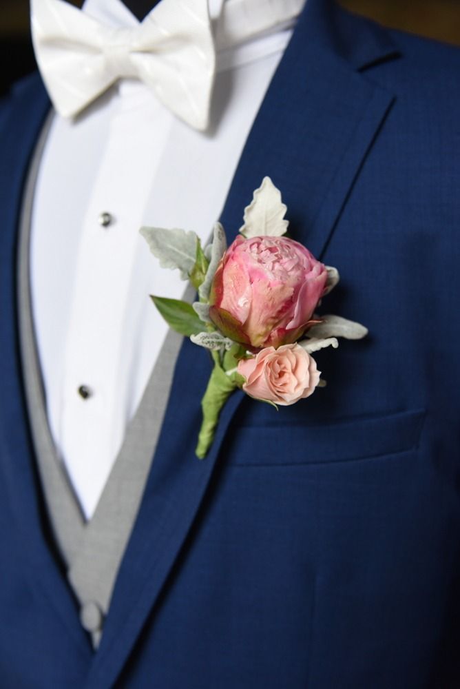 Navy blue suit with white bow tie and pink rose boutonniere.