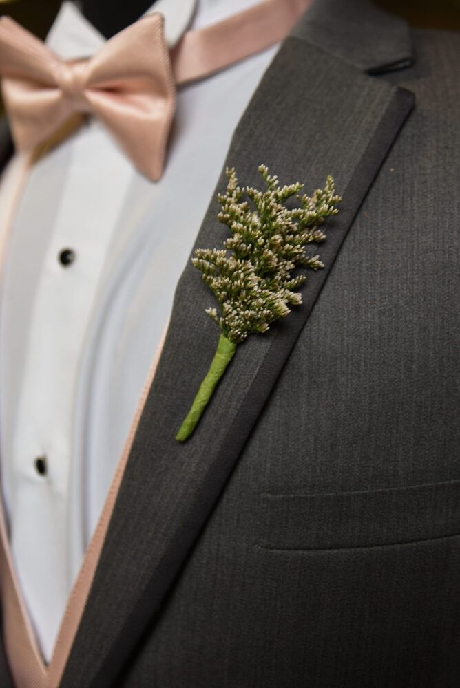 Gray suit with peach bow tie and boutonniere.