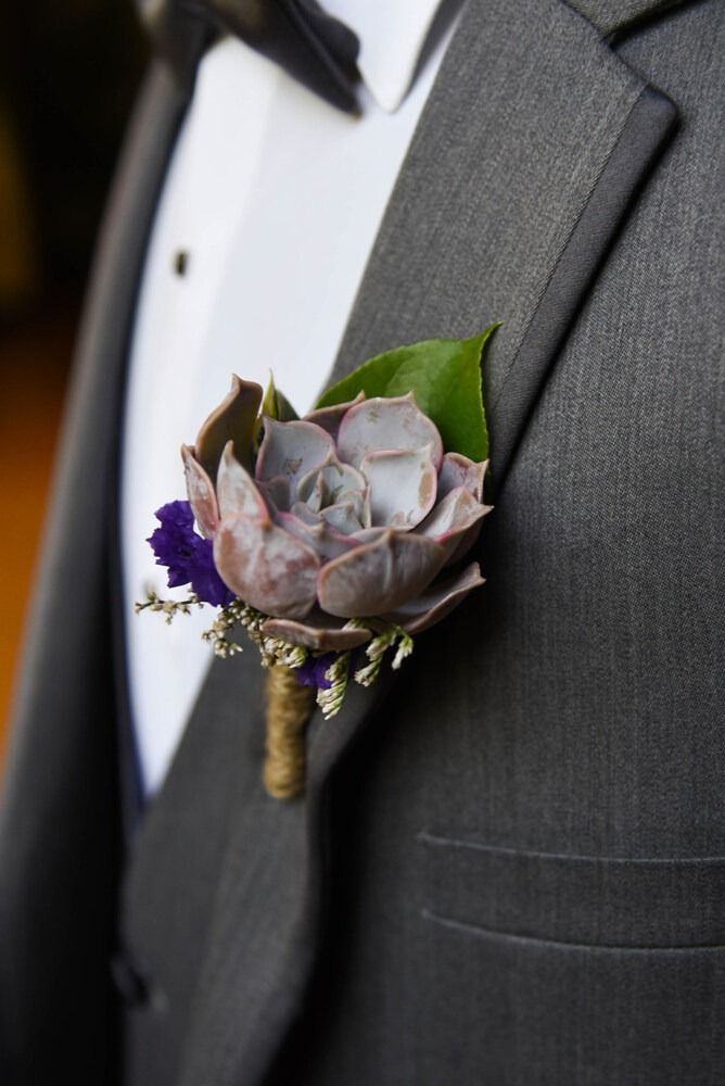 Gray tuxedo jacket with succulent boutonniere: purple, green, and gold.