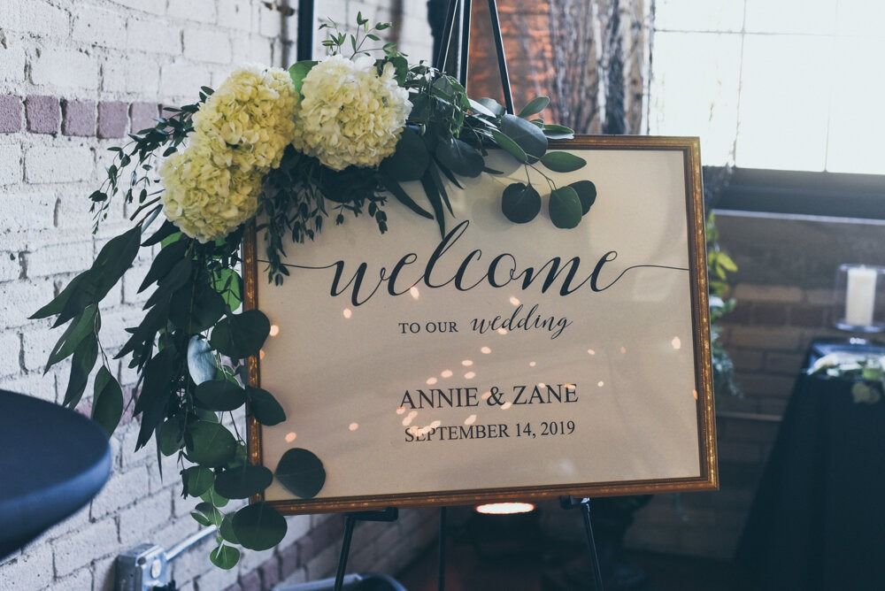 Wedding welcome sign with floral arrangement. 