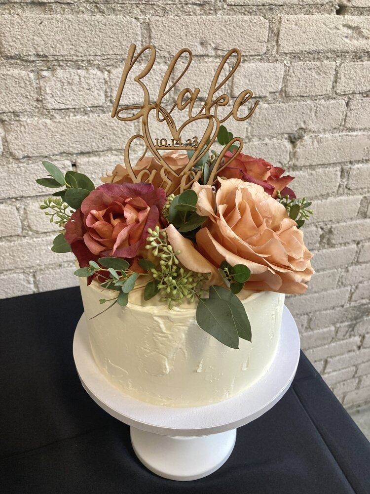 Cake with floral arrangement and wooden 