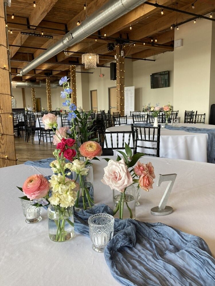 Table setting with flower arrangements, blue runner, and table number 
