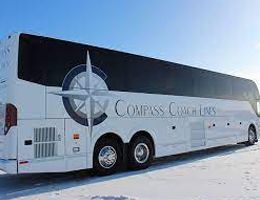 White Compass Coach Lines bus with a compass rose logo on snow.