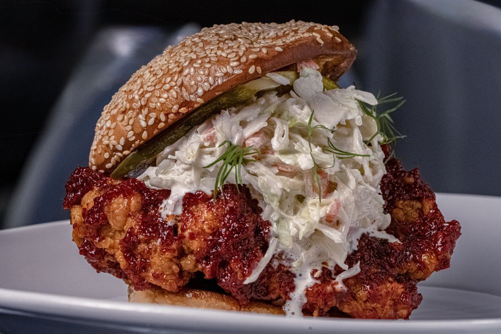 Sesame bun fried chicken sandwich with creamy slaw on a plate