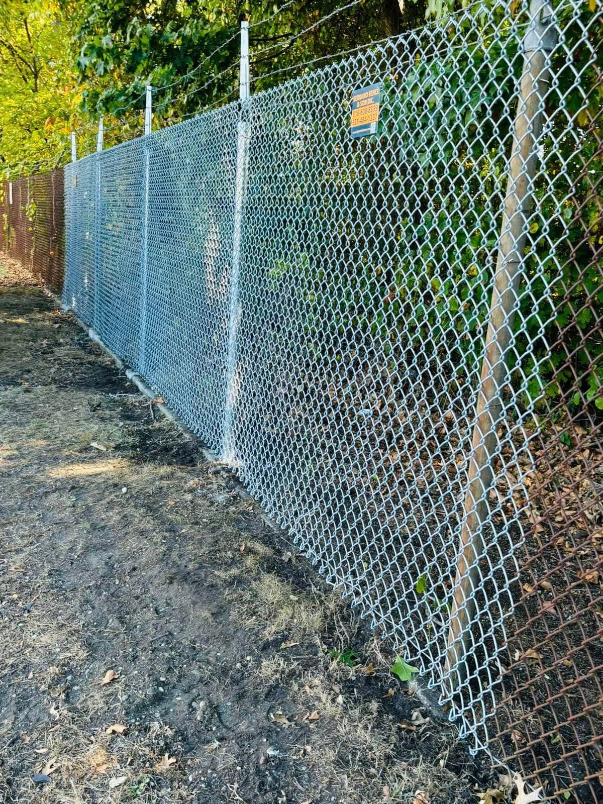 Chain link fence with barbed wire topper, outdoors.