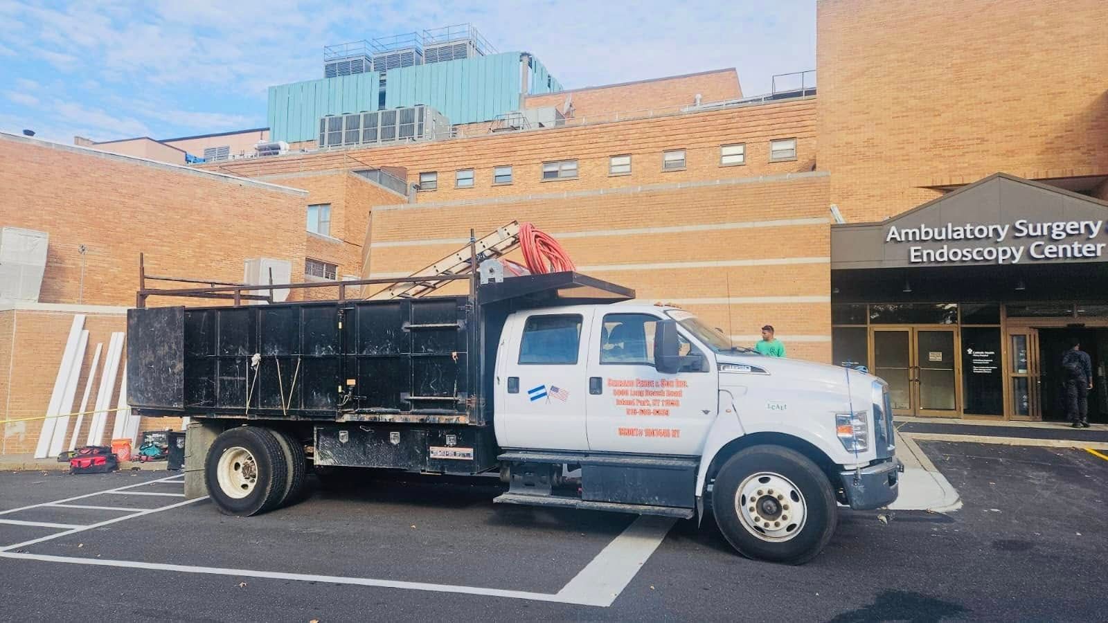 White dump truck parked outside a building with 