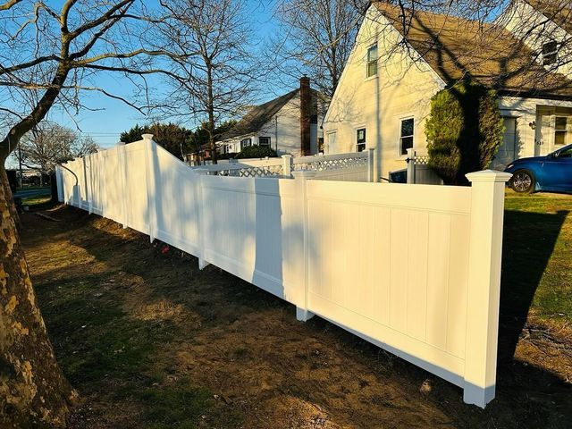White vinyl fence along a suburban yard beside a house on a sunny day