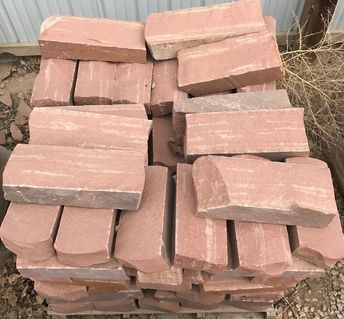 A pile of red bricks stacked on top of each other