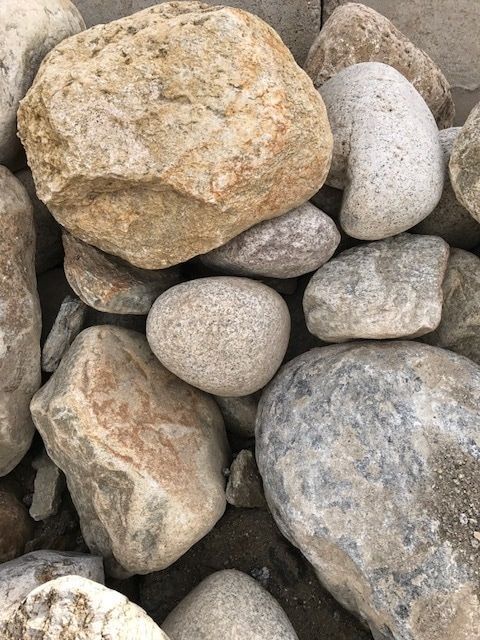 A pile of rocks sitting on top of each other on the ground.