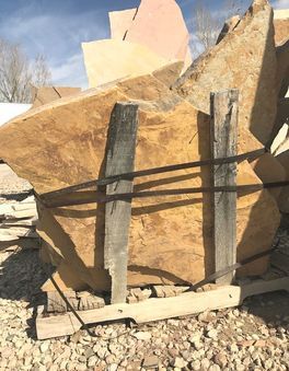 A large piece of wood is sitting on top of a pile of rocks.