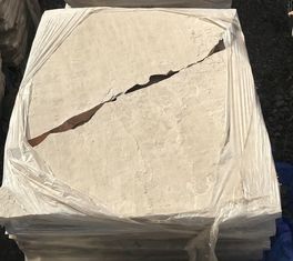 A stack of tiles wrapped in plastic with one tile missing.