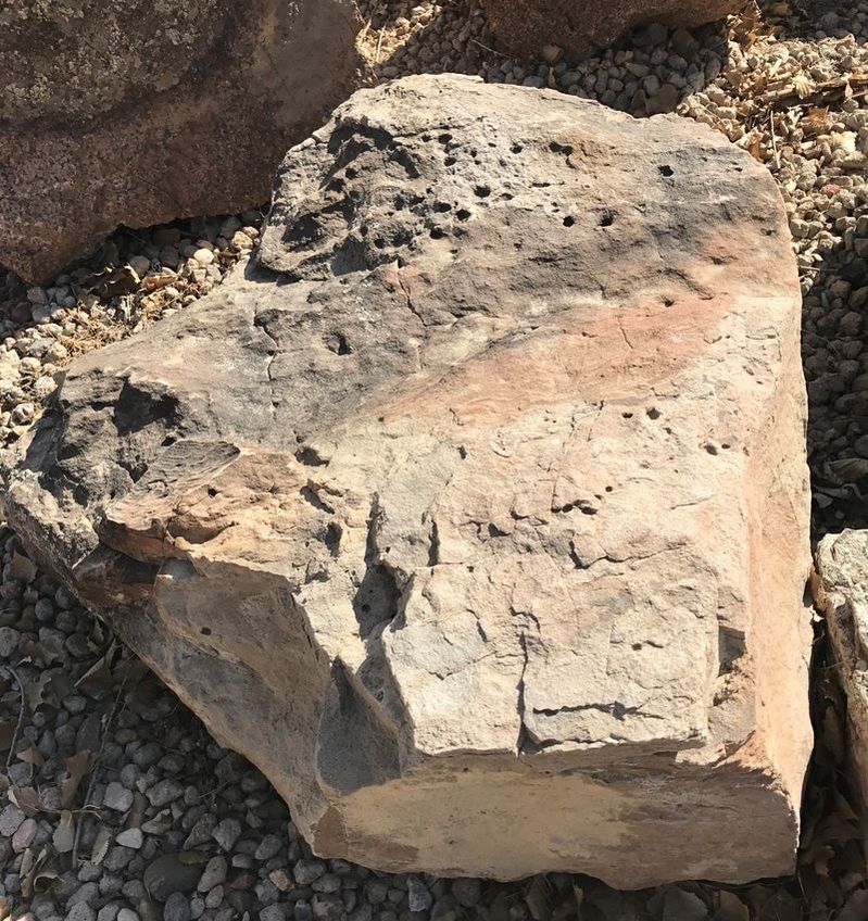 A large rock is sitting on a pile of gravel