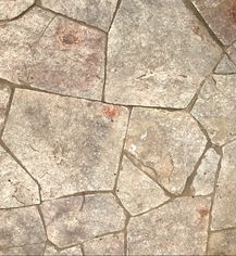 A close up of a stone floor with a concrete border.
