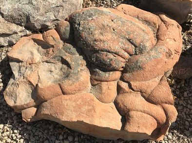 A large rock is sitting on top of a pile of gravel.