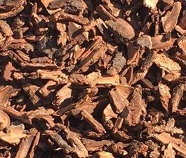 A pile of wood chips is sitting on the ground.
