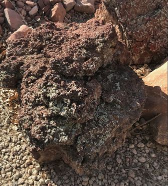 A large rock is sitting on top of a pile of gravel.