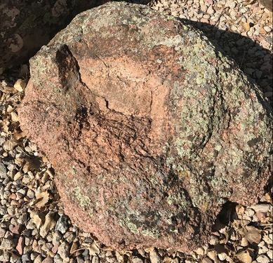 A large rock is sitting on a pile of gravel