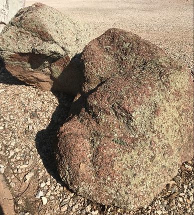 A large rock is sitting on top of a pile of gravel.