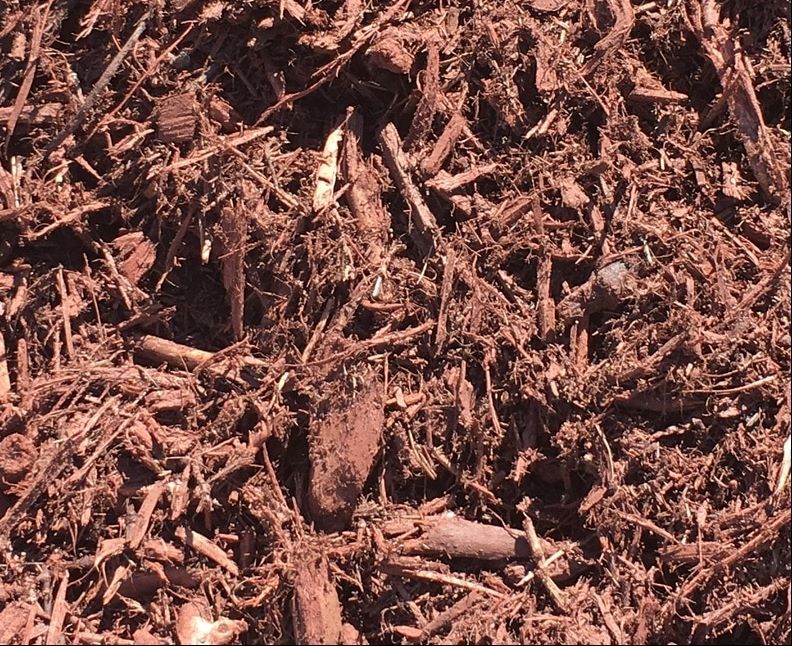 A pile of brown mulch is sitting on the ground