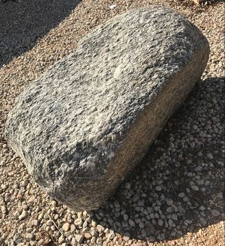 A large rock is sitting on top of a pile of gravel.