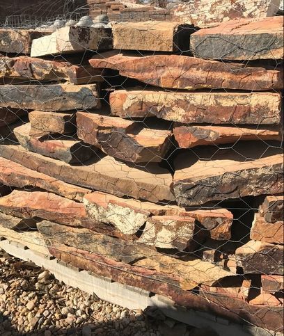 A pile of rocks stacked on top of each other behind a chain link fence.