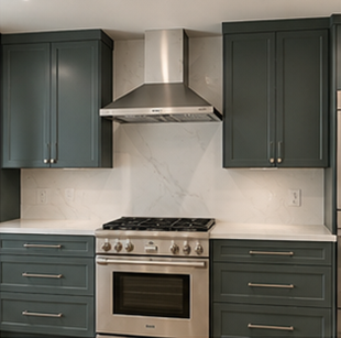 Modern kitchen with dark green cabinets, white countertops, stainless steel range and hood