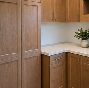 Wooden kitchen cabinets and white countertop in a clean corner nook